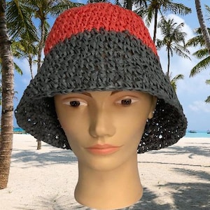 Peut inclure: Un chapeau de soleil en crochet gris et corail avec une large bordure. Le chapeau est fait d'un matériau léger et a un style décontracté et détendu.