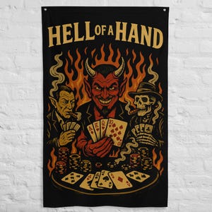 May include: Black wall flag featuring a poker game scene with a devil, a vampire, and a skeleton. The devil holds a winning hand. The text "HELL OF A HAND" is at the top in gold letters. Flames and poker chips are also visible.