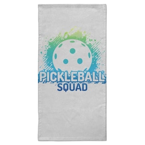 Può includere: Asciugamano bianco con un design pickleball. Il design presenta una pallina da pickleball bianca con tre fori, su uno sfondo a spruzzi blu e verdi. Le parole "PICKLEBALL SQUAD" sono stampate in blu.
