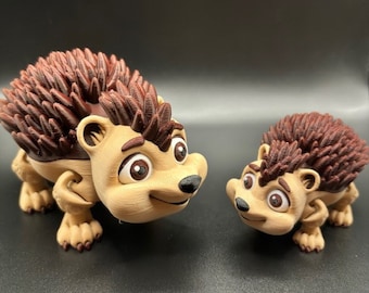 May include: Two brown and tan 3D printed figurines of hedgehogs with brown spines. The larger hedgehog is looking to the right and the smaller hedgehog is looking to the left.
