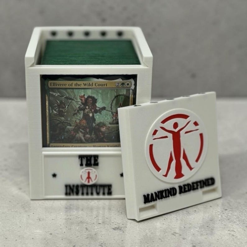 Pu&ograve; includere: Una scatola bianca per riporre carte con interno verde, contenente una carta con grafica e testo. La scatola presenta la scritta "THE INSTITUTE" e un logo. &Egrave; presente anche un portacarte bianco separato con la scritta "MANKIND REDEFINED" e un logo rosso.