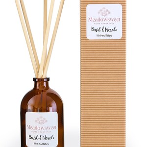 May include: A brown glass reed diffuser bottle with wooden reeds and a matching box. The label reads "Meadowsweet HOME FRAGRANCE Basil & Neroli 100ml Reed Diffuser."