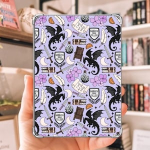 May include: A rectangular, clear-cased tablet with a repeating pattern of black dragons, swords, moons, feathers, and text on a lavender background. The text includes "BASRATH WAR COLLEGE" and "I will not die today".