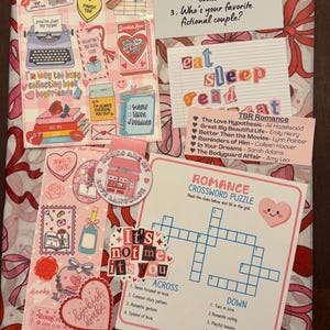 Può includere: Una collezione di adesivi a tema libri, un cruciverba e un elenco di romanzi rosa. Gli adesivi presentano cuori, libri e frasi come "Bookish Valentine Club" e "Eat Sleep Read". Il cruciverba si intitola "Romance Crossword Puzzle".