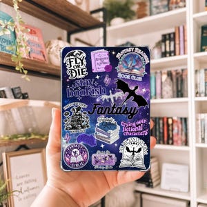 May include: A clear phone case with a galaxy-themed design and fantasy-themed stickers. The stickers include dragons, books, and the words "Fantasy," "Book Club," and "Stay Bookish." The case is held in a hand.