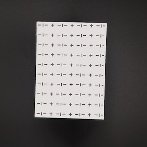 Rectangular sashiko design of crosses and dashes on a black background.