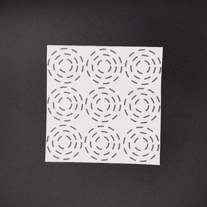 Square sashiko transfer of a 3 x 3 concentric circles sashiko stitching design. Shown on a black background