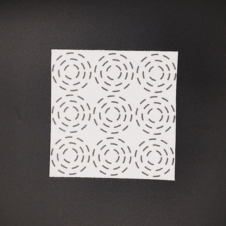 Square sashiko transfer of a 3 x 3 concentric circles sashiko stitching design. Shown on a black background