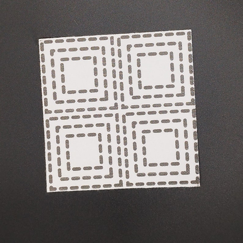 Square sashiko pattern of 4 concentric squares on white transfer on a black background.