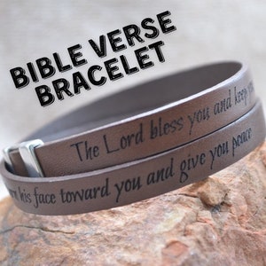 May include: A brown leather bracelet with the text "The Lord bless you and keep you" and "Turn his face toward you and give you peace" engraved on it.