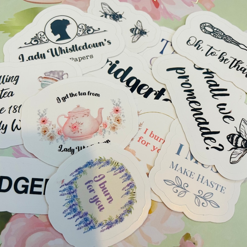 May include: A set of 10 white round stickers with black text and illustrations. The stickers feature quotes and phrases from the popular television show Bridgerton. Some of the quotes include "I burn for you", "Shall we promenade?" and "Oh, to be that ridge".