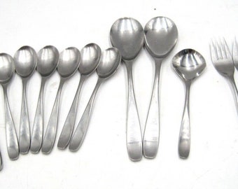 May include: A set of silverware, including knives, forks, and spoons, all made of stainless steel. The silverware is arranged in a row on a white surface.