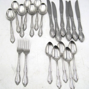 May include: A set of stainless steel silverware, including spoons, forks, and knives. The silverware has an ornate design with a decorative handle.
