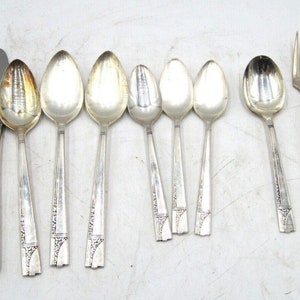 May include: A set of silverware with a silver finish. The set includes knives, spoons, and forks. The silverware has an ornate design with a floral pattern.