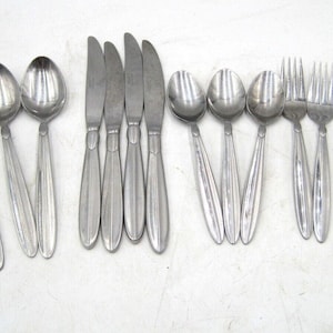 May include: A set of silverware, including spoons, forks, and knives, all made of stainless steel. The silverware has a sleek, modern design with a brushed finish.