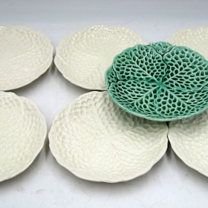 May include: Set of six white ceramic plates with a cabbage leaf design. One plate is green.