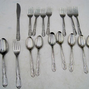 May include: A set of cutlery, including forks, spoons, and a knife, all made of stainless steel. The cutlery has an ornate design with a floral pattern.