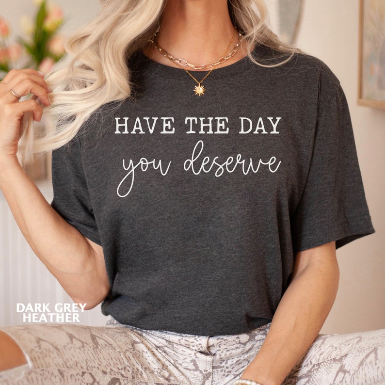 May include: Dark grey heather t-shirt with the text "Have the day you deserve" in white.