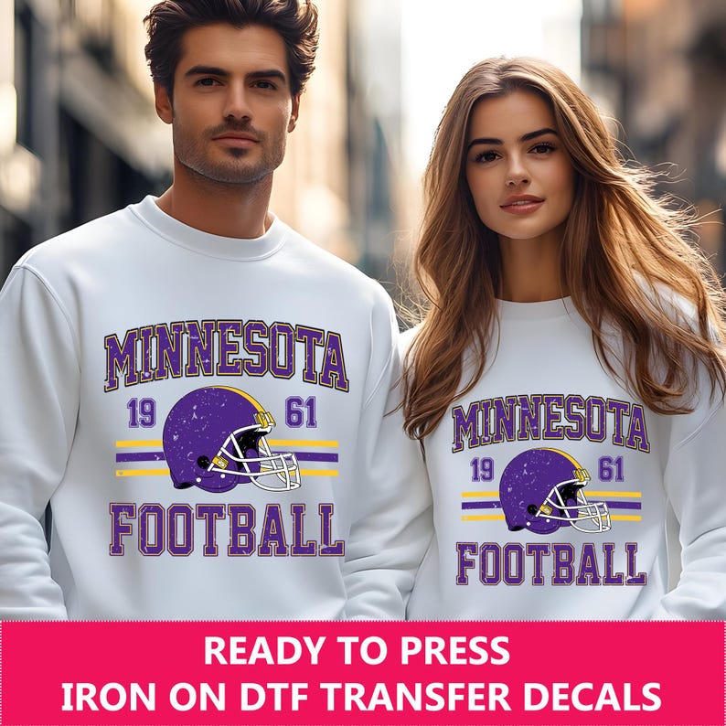 May include: White sweatshirt with a purple and yellow Minnesota Football design. The design includes a football helmet with a distressed look and the years 19 and 61.
