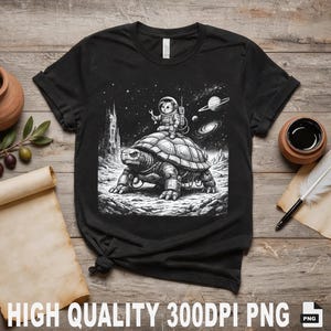 Peut inclure: T-shirt noir avec un motif d'astronaute de dessin animé chevauchant une tortue géante dans l'espace. Le design comprend des planètes et des étoiles. Le t-shirt est en matière souple. L'image contient le texte "HIGH QUALITY 300DPI PNG".