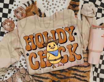 Peut inclure: Un sweat-shirt beige avec le texte "Howdy Chick" en lettres brunes et un poussin de dessin animé portant un chapeau de cowboy et un bandana bleu. Le poussin tient un lasso et a une ceinture marron.