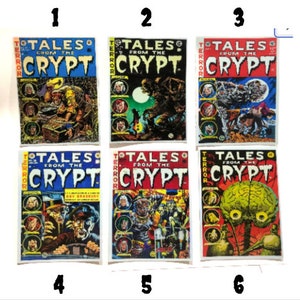 K&ouml;nnte beinhalten: Sechs Vintage-Comic-Cover mit dem Titel "Tales from the Crypt". Die Cover sind alle in Rot, Wei&szlig; und Blau mit Schwarzwei&szlig;illustrationen von Horrorszenen. Die Cover sind von 1 bis 6 nummeriert.