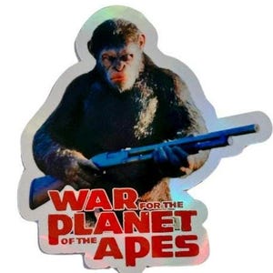 May include: A sticker featuring a chimpanzee holding a shotgun. The sticker has a holographic finish and the text "War for the Planet of the Apes" in red.