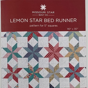 May include: A colorful quilt pattern for a bed runner. The design features star shapes in various colors, including red, blue, and green, set against a white background. The bed runner measures 110 inches by 30 inches.