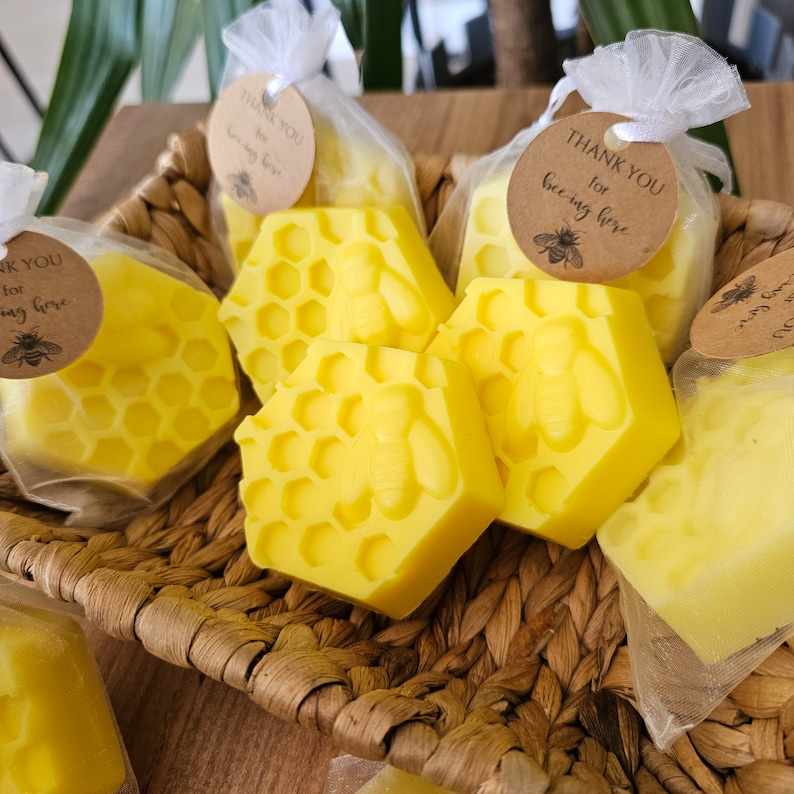 May include: Yellow honeycomb-shaped soaps with a bee design, packaged in clear bags with a thank you tag that says "Thank you for bee-ing here".