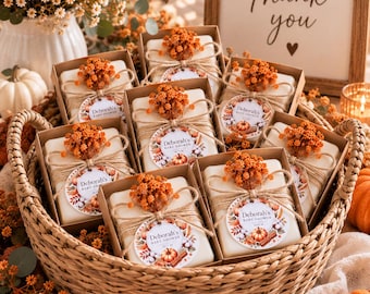 May include: A collection of rectangular white soap bars packaged in brown cardboard boxes, each tied with twine and topped with dried orange flowers. A circular tag on each box features the text Deborah's Baby Shower with pumpkin graphics.