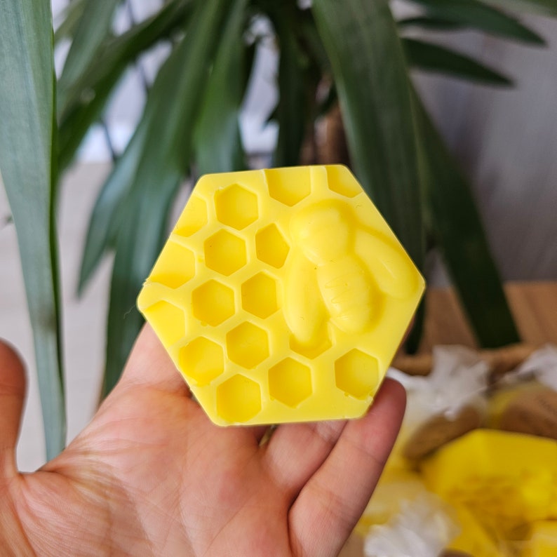 May include: A yellow honeycomb-shaped soap bar with a small bear design in the center.