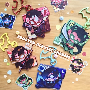 May include: A set of ten frosted acrylic charms featuring different characters from the DC Comics universe. The charms are colourful and feature various poses and expressions. The charms are attached to keychains and are perfect for adding a touch of fandom to your keys, bags, or backpacks.