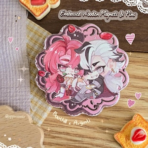 May include: Embossed wooden magnet with a cartoon illustration of two characters with pink and white hair, embracing. The magnet has a pink border and the text "Boothill x Argenti". The top text reads "Embossed Wooden Magnets & Pins".