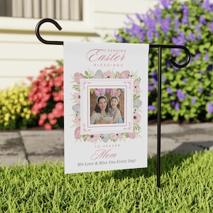 May include: A white garden flag with a pink and green floral design. The flag features a photo of a mother and daughter with bunny ears. The text on the flag reads "Sending Easter Blessings to Heaven Mom We Love & Miss You Every Day!"