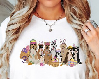 May include: White t-shirt with a graphic of dogs wearing bunny ears and holding Easter eggs. The dogs are a variety of breeds and colors.