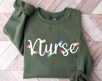May include: A green sweatshirt with the word "Nurse" written in white with colorful light bulbs around the letters.