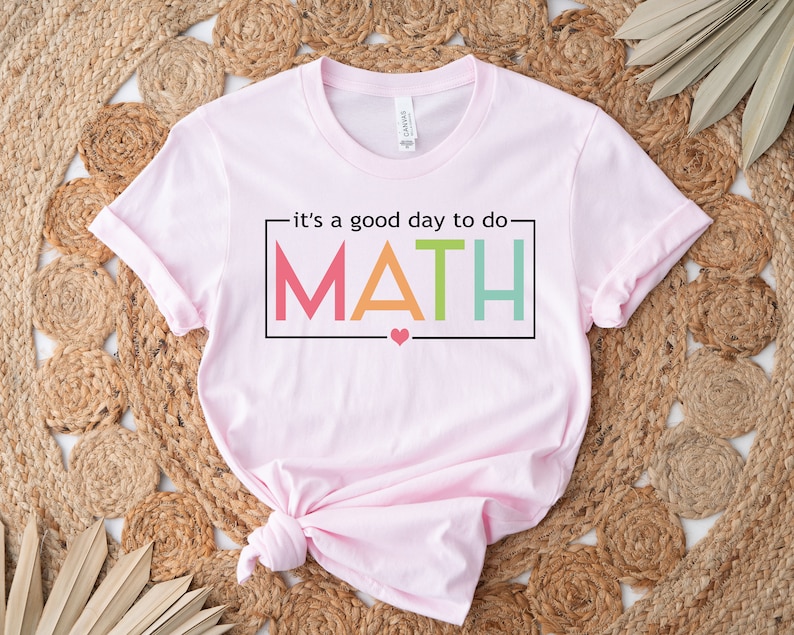 May include: Pink t-shirt with the text "it's a good day to do MATH" in rainbow colors. A small heart is below the text.