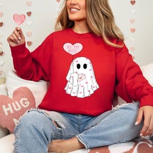 May include: Red sweatshirt with a white ghost graphic holding a pink heart balloon that says "Be My Boo".