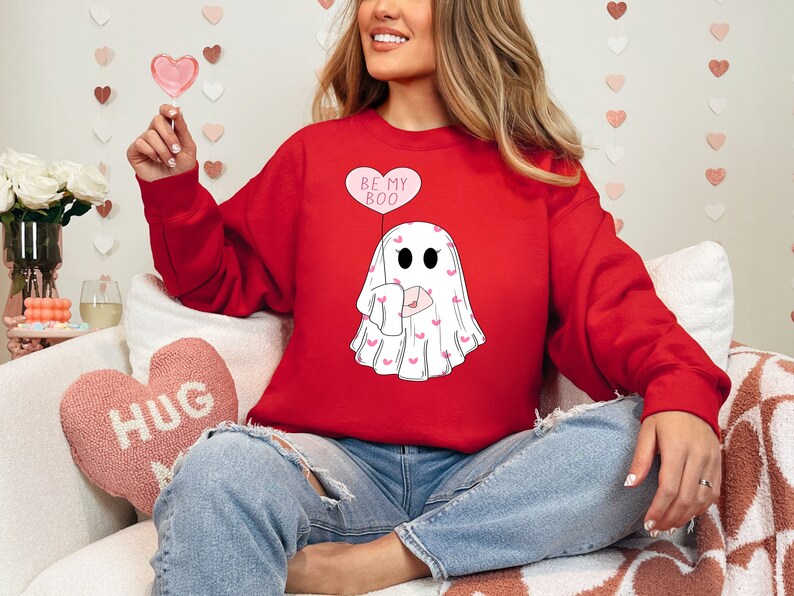 May include: Red sweatshirt with a white ghost graphic holding a pink heart balloon that says "Be My Boo".