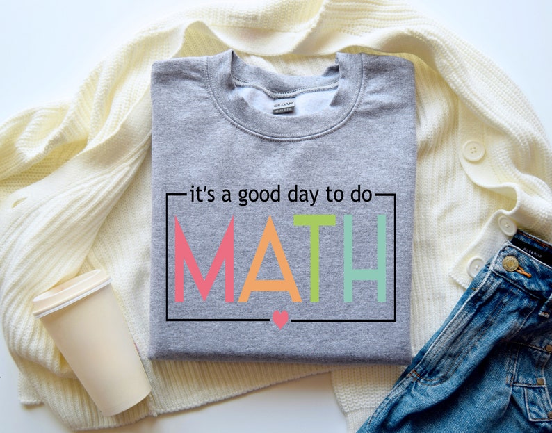 May include: Gray sweatshirt with the text "it's a good day to do MATH" in a colorful rainbow font. The letters are outlined in black and there is a small pink heart below the word MATH.