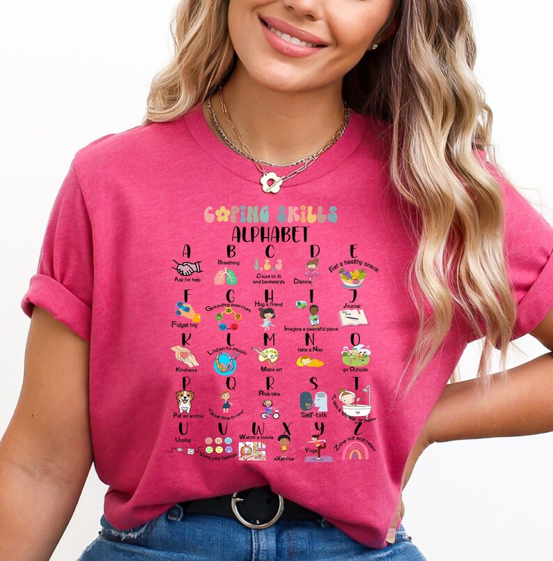May include: Pink t-shirt with a colorful alphabet chart that lists coping skills for each letter. The chart is titled "Coping Skills Alphabet".