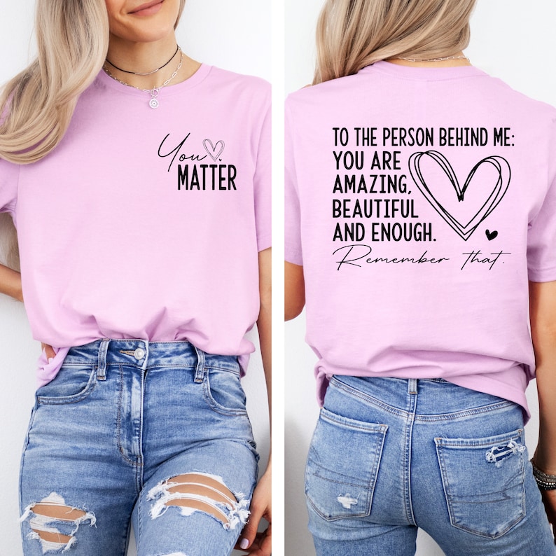 May include: A light pink t-shirt with the text "You Matter" and a heart on the front. The back of the shirt has the text "To the person behind me: You are amazing, beautiful and enough. Remember that." with a large heart design.