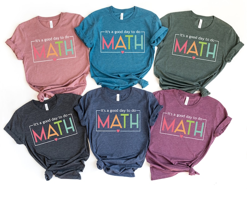 May include: Six t-shirts in different colors with the text "It's a good day to do MATH" in a colorful, outlined box. The text is in a white box with a small pink heart.