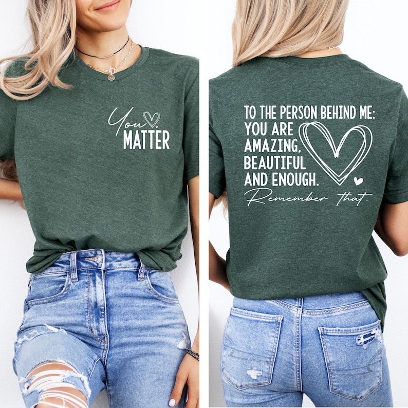 May include: A green t-shirt with the text "You Matter" on the front and "To the person behind me: You are amazing, beautiful and enough. Remember that." on the back. The shirt is being modeled by a person wearing blue jeans.