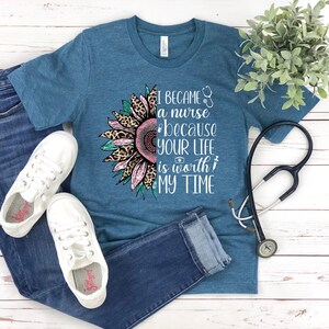 May include: Teal blue t-shirt with a sunflower graphic and the text "I became a nurse because your life is worth my time".