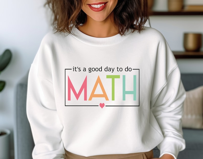 May include: White sweatshirt with the text "it's a good day to do MATH" in a colorful rainbow font with a small pink heart below the text.