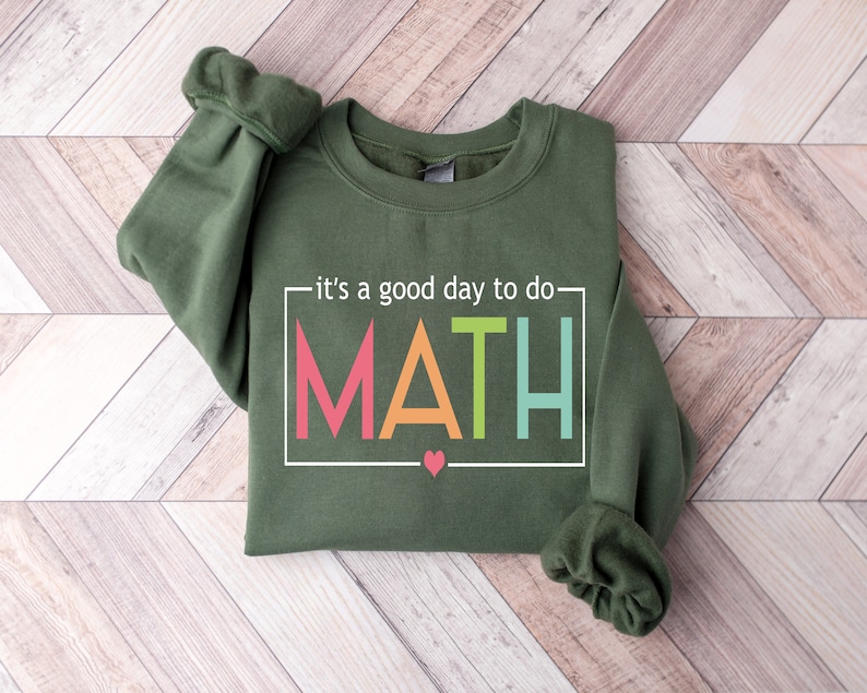 May include: A green sweatshirt with the text "it's a good day to do MATH" in a white box with colorful letters. A small pink heart is below the text.