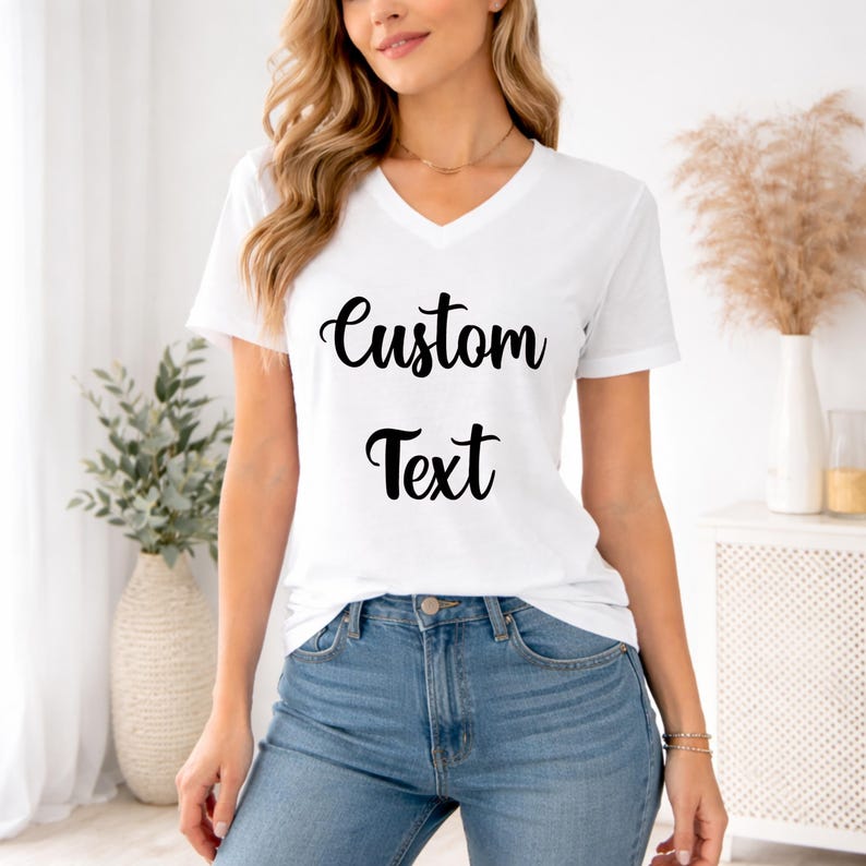 A woman wearing a white t-shirt with the text "Custom Text" printed on it, standing in a room with a potted plant and a vase.