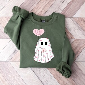 May include: A green sweatshirt with a white ghost holding a pink heart balloon that says "Be My Boo".