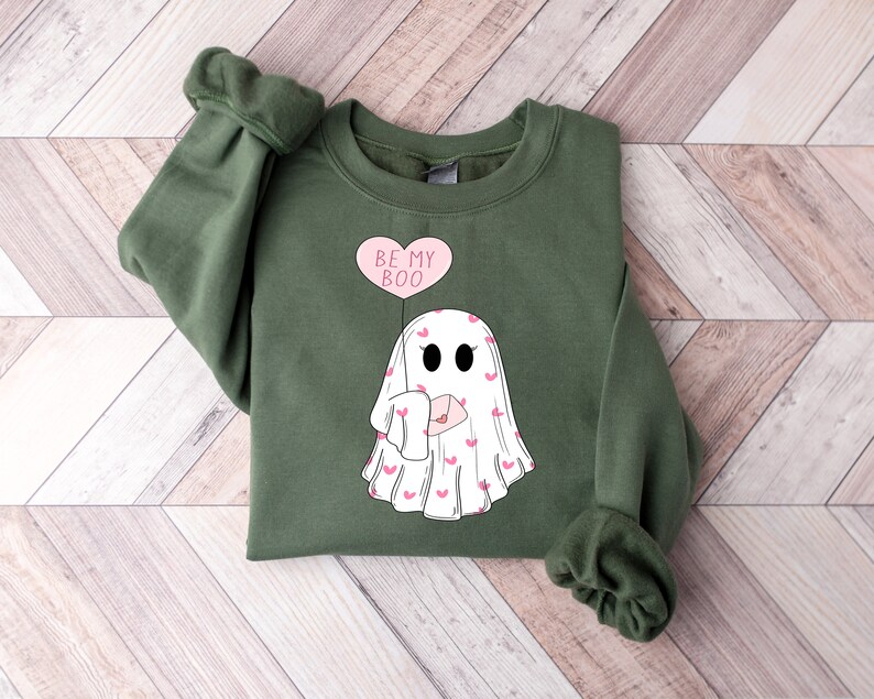 May include: A green sweatshirt with a white ghost holding a pink heart balloon that says "Be My Boo".